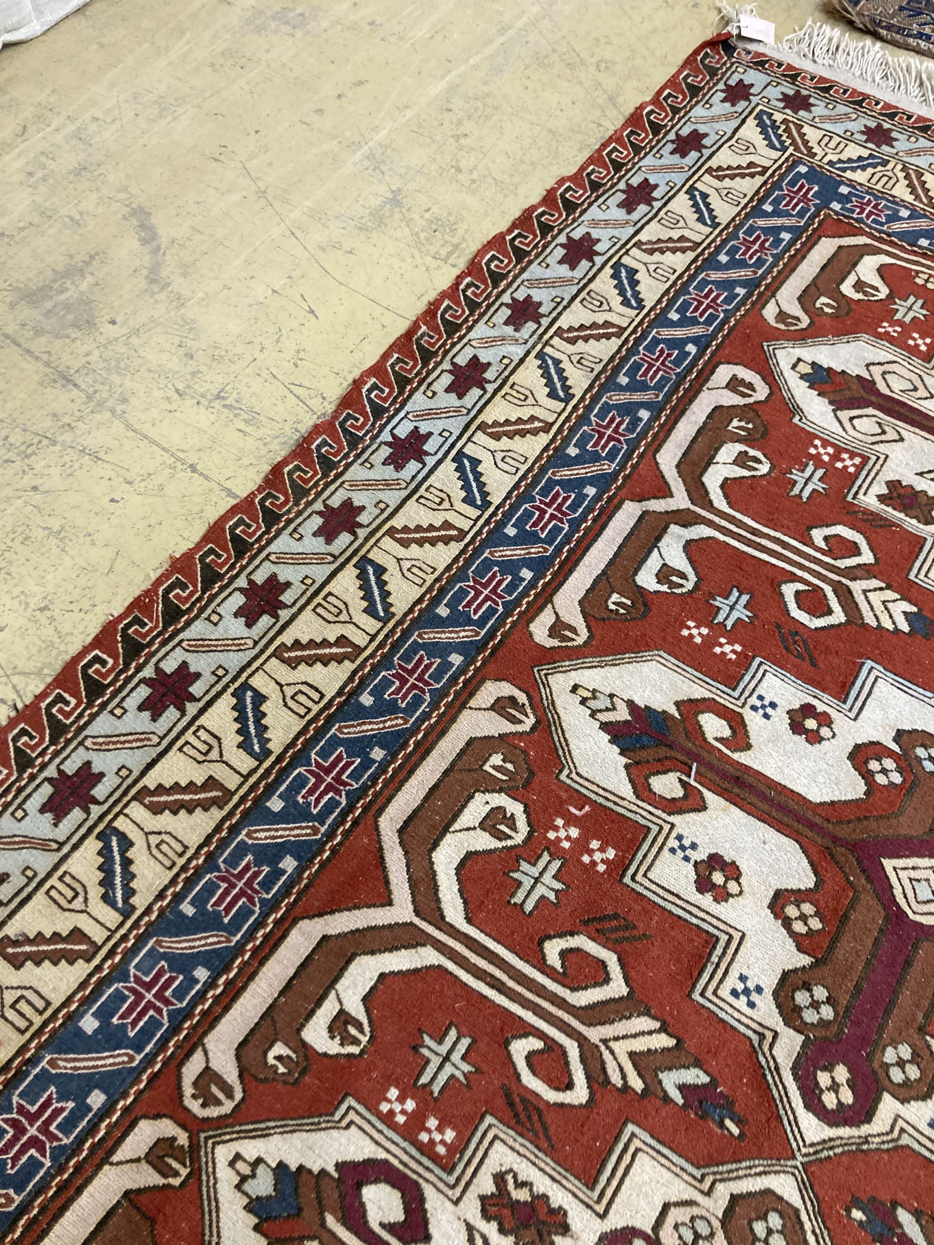 A Caucasian design red ground rug, 240 x 165 cms.